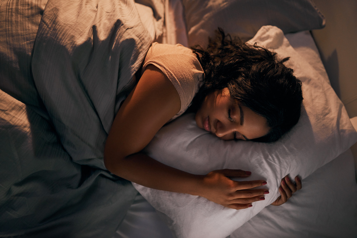 woman sleeping in a bed with covers